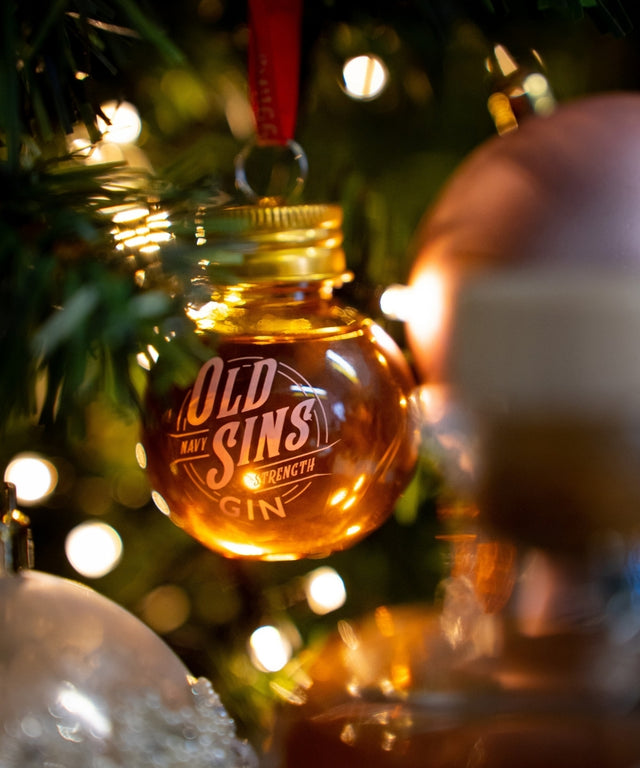 An old sins gin bauble hanging on a xmas tree